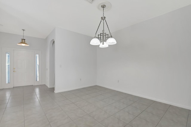 tiled empty room with a notable chandelier