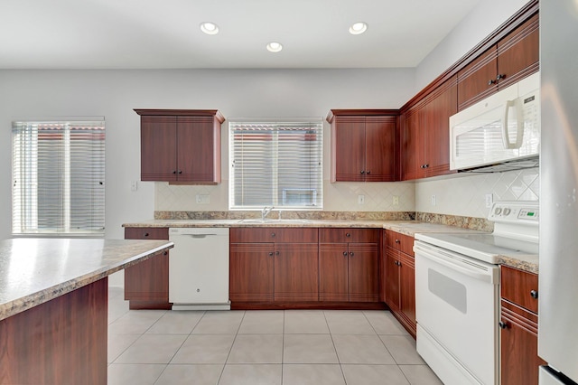 kitchen with light tile patterned floors, white appliances, sink, and backsplash