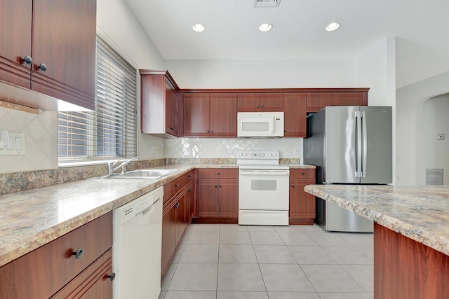 kitchen with sink, white appliances, light tile patterned floors, and backsplash