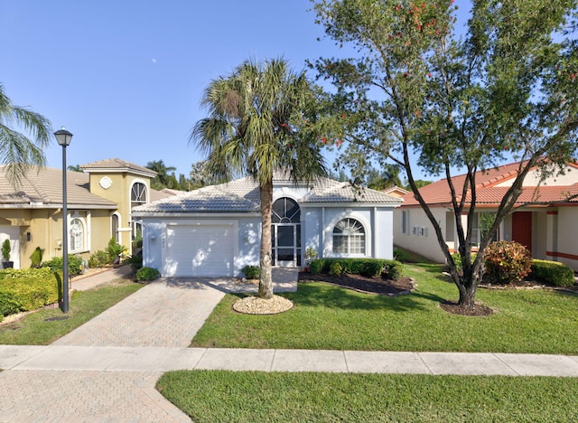 mediterranean / spanish-style house featuring a garage and a front yard