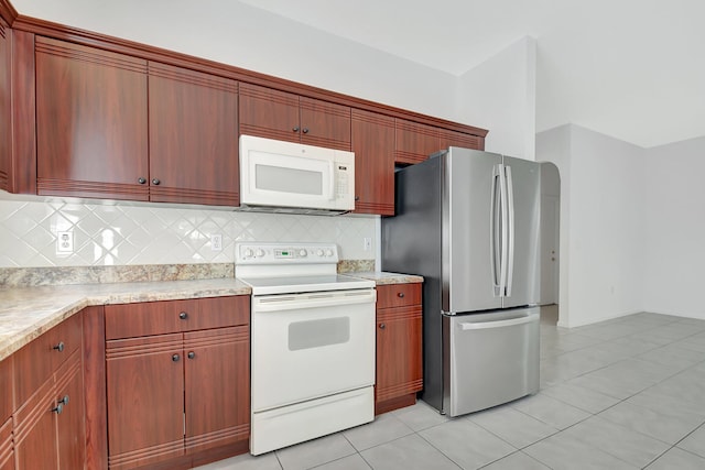 kitchen with white appliances, light tile patterned floors, and backsplash