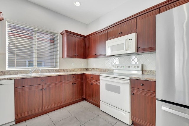 kitchen with backsplash, white appliances, sink, and light tile patterned floors