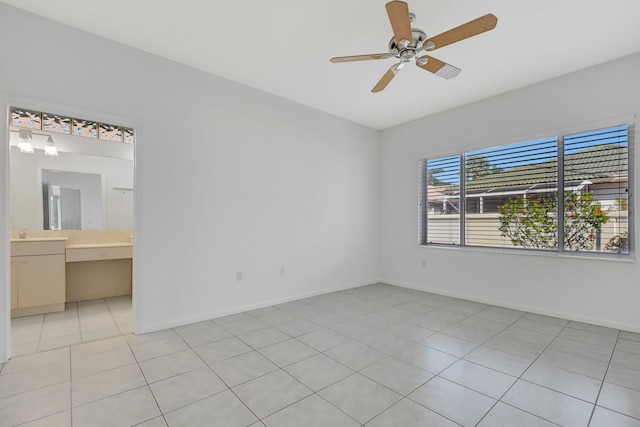 tiled spare room featuring ceiling fan