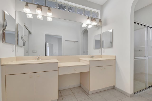 bathroom with tile patterned flooring, vanity, and walk in shower