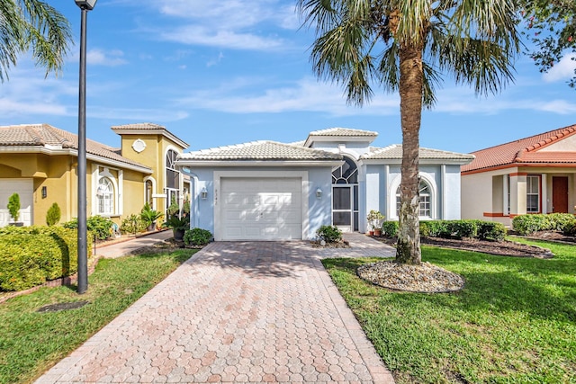 mediterranean / spanish-style house with a garage and a front lawn