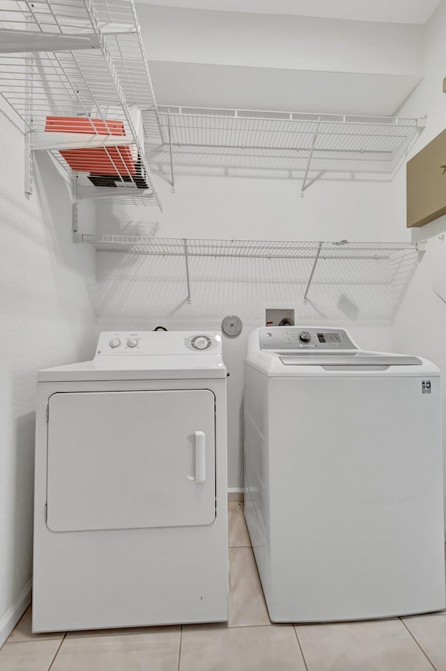 laundry area featuring light tile patterned floors and washer and dryer