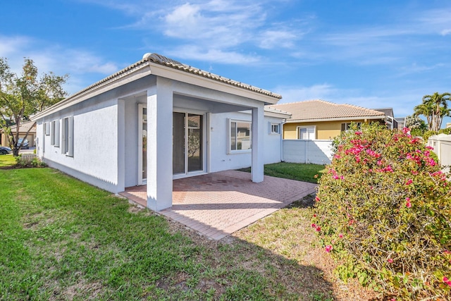 rear view of property featuring a yard and a patio area