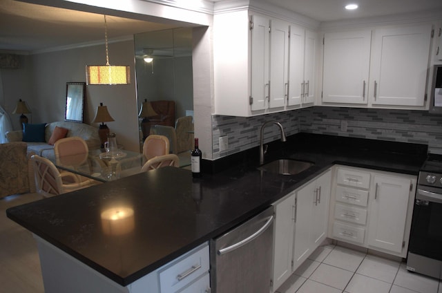 kitchen with appliances with stainless steel finishes, tasteful backsplash, white cabinetry, sink, and ornamental molding