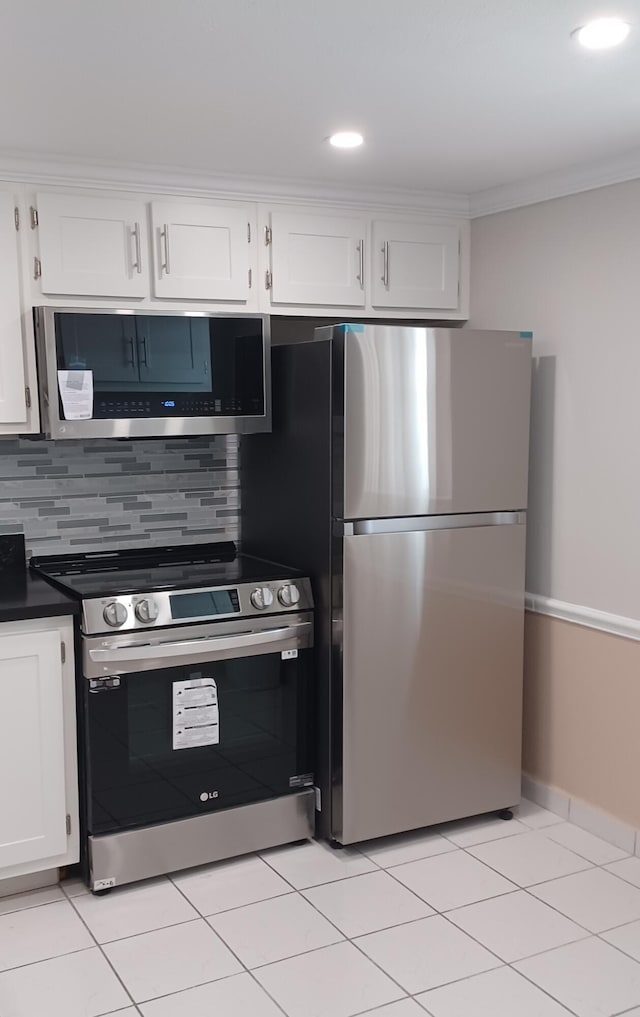 kitchen featuring stainless steel appliances, white cabinetry, and tasteful backsplash