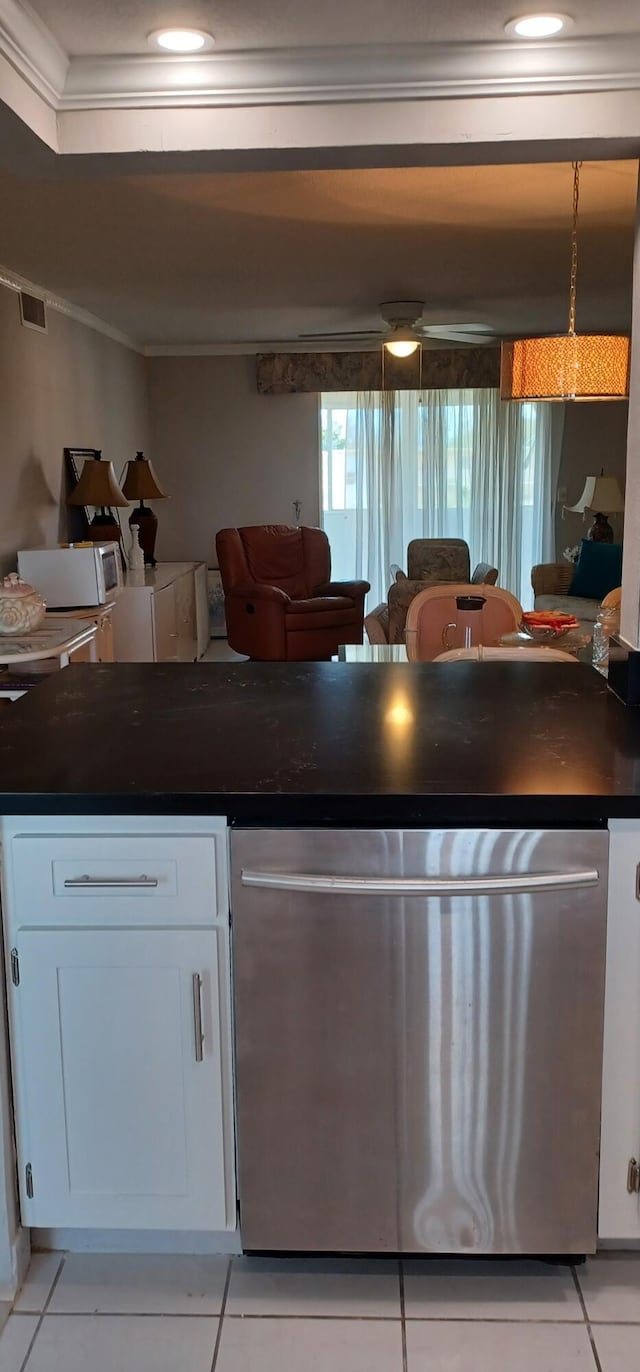 kitchen featuring light tile patterned floors, ornamental molding, stainless steel dishwasher, and white cabinets