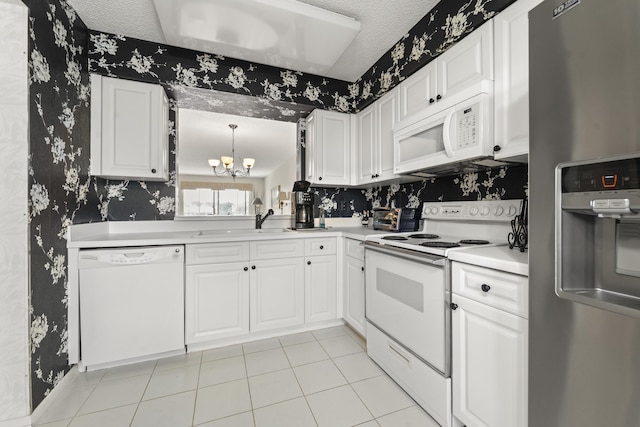 kitchen with white appliances, sink, and white cabinets