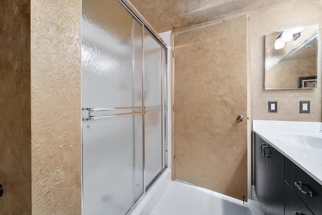 bathroom featuring vanity, tile patterned flooring, and a shower with door