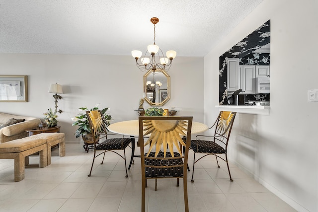 tiled dining area featuring a textured ceiling and a chandelier