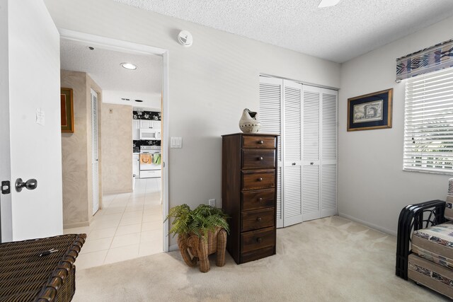 kitchen with white cabinetry, white appliances, and a textured ceiling