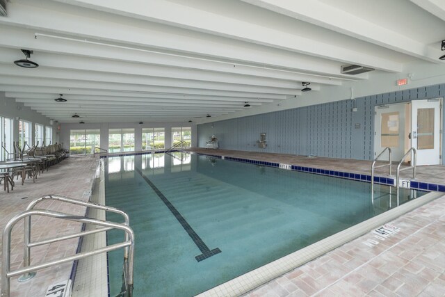 exercise room featuring a paneled ceiling and dark colored carpet