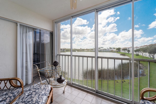 sunroom featuring a water view and ceiling fan