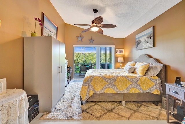 bedroom featuring ceiling fan, access to exterior, vaulted ceiling, and a textured ceiling