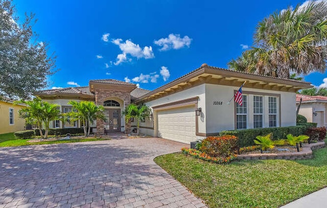 mediterranean / spanish-style home featuring a garage and a front yard