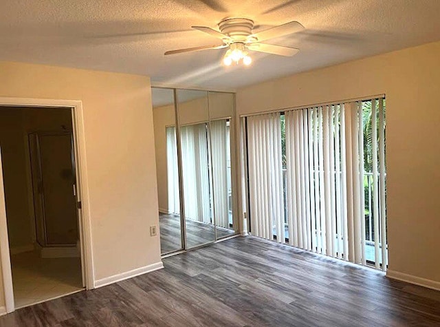 empty room featuring ceiling fan, a textured ceiling, and dark hardwood / wood-style flooring