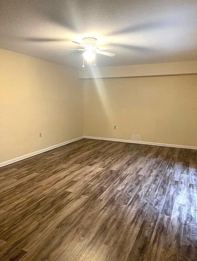 spare room with a textured ceiling, dark hardwood / wood-style floors, and ceiling fan