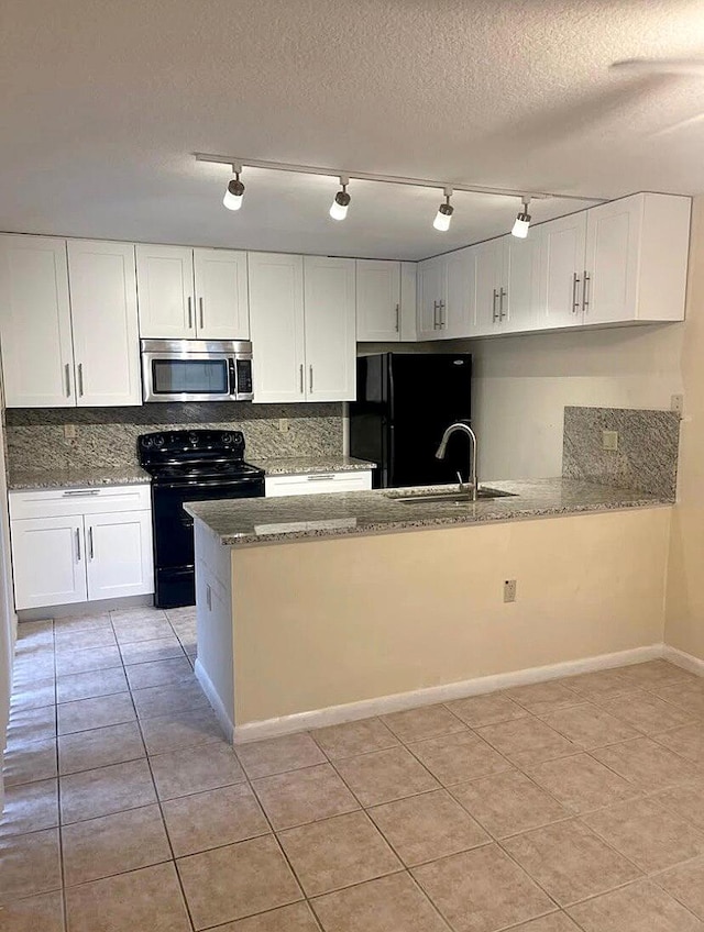 kitchen with sink, tasteful backsplash, black appliances, kitchen peninsula, and white cabinets