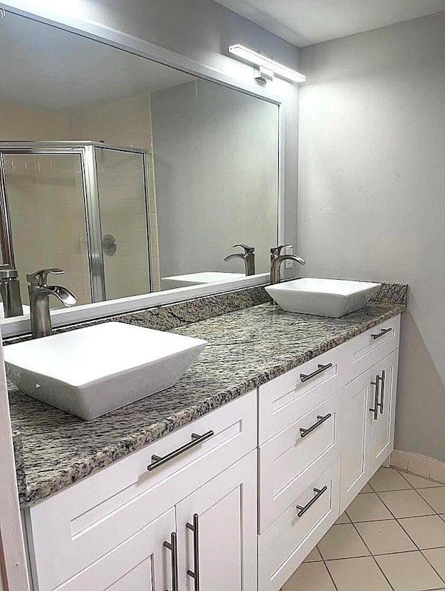 bathroom featuring vanity, tile patterned floors, and walk in shower