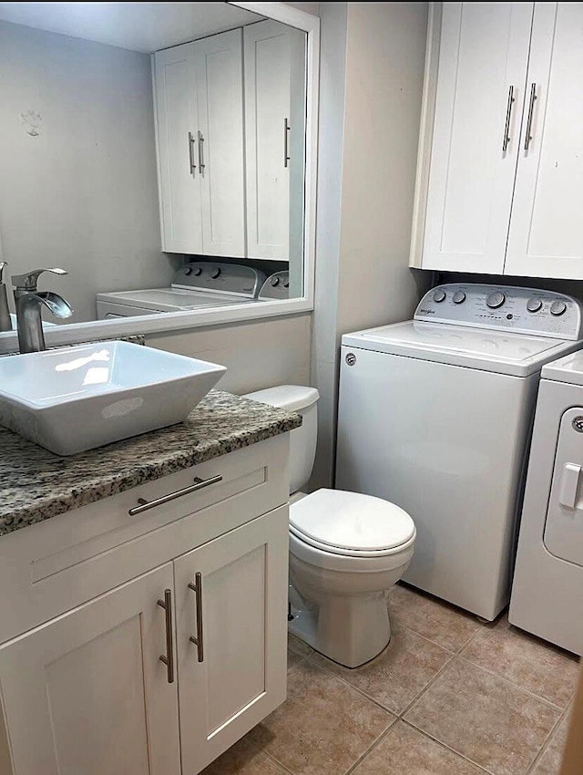 bathroom featuring tile patterned floors, vanity, toilet, and washer and clothes dryer