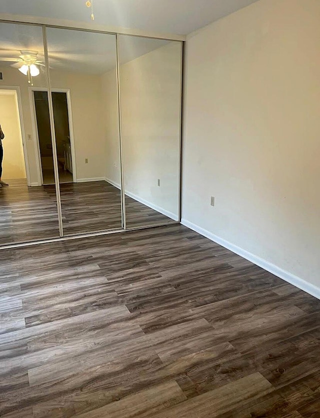 unfurnished bedroom featuring dark hardwood / wood-style flooring and a closet