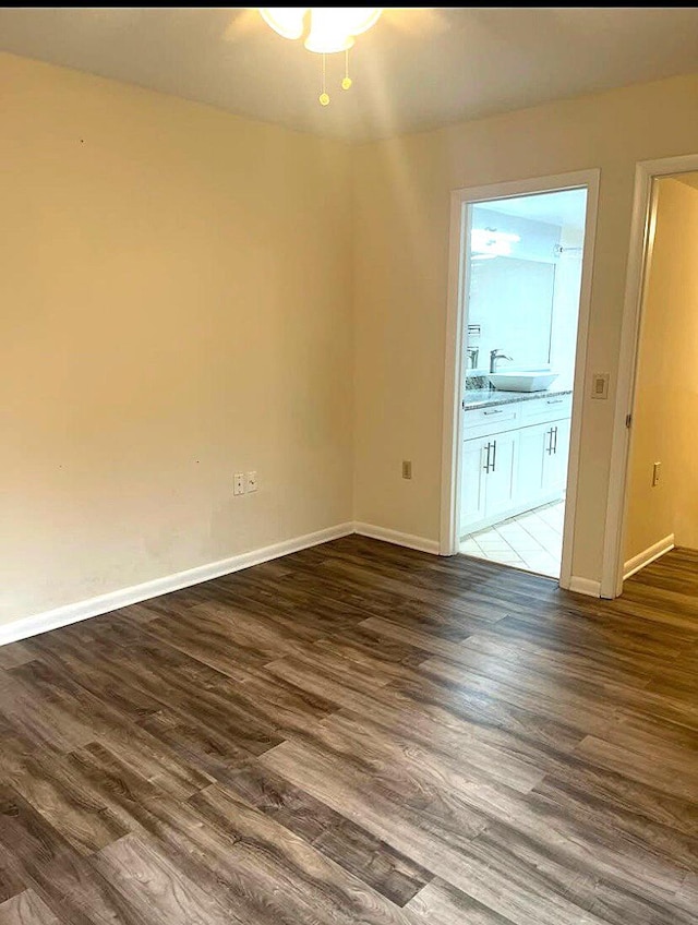 spare room featuring sink and dark hardwood / wood-style flooring