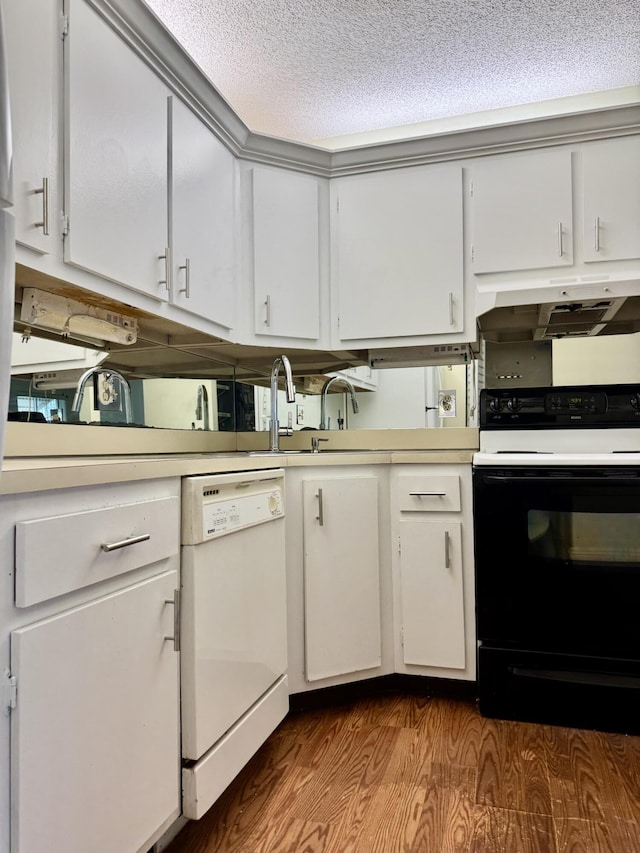 kitchen with black electric range oven, hardwood / wood-style flooring, white cabinetry, white dishwasher, and a textured ceiling