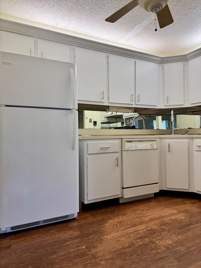 kitchen with dark wood-type flooring, sink, white cabinets, and white appliances