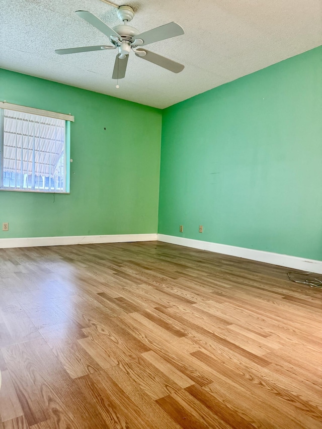 unfurnished room featuring ceiling fan, light hardwood / wood-style floors, and a textured ceiling