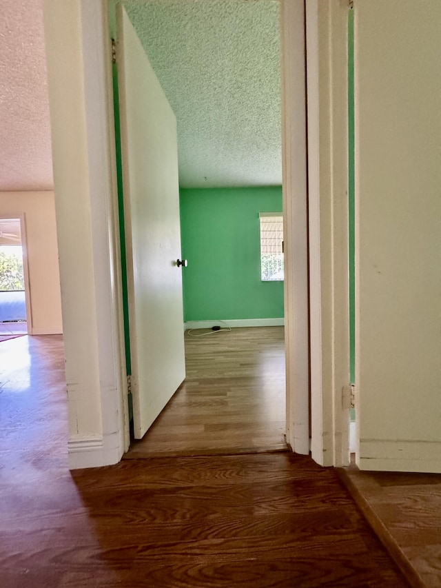 hall featuring hardwood / wood-style floors and a textured ceiling