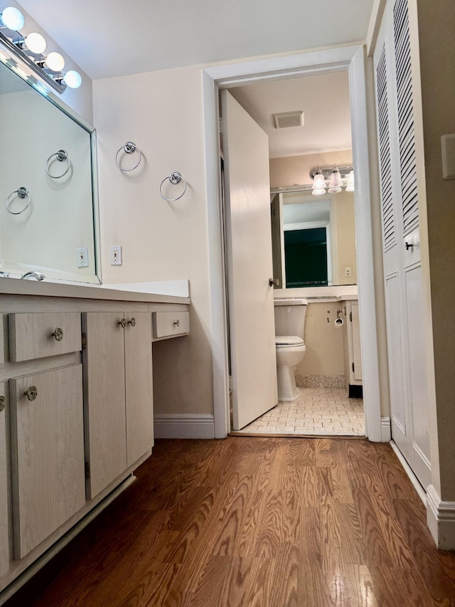 bathroom featuring hardwood / wood-style flooring, vanity, and toilet