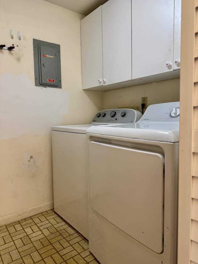 clothes washing area featuring cabinets, washing machine and clothes dryer, and electric panel