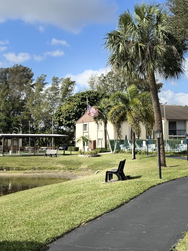 surrounding community featuring a water view and a lawn