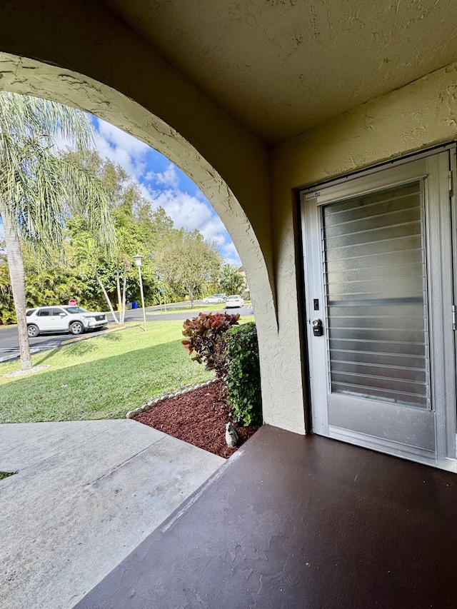 entrance to property featuring a lawn