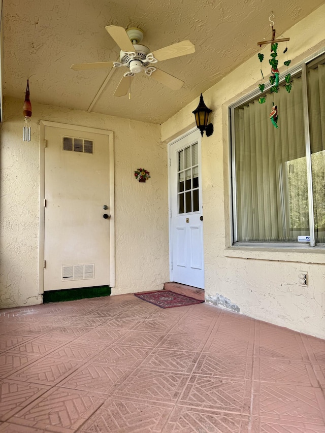 doorway to property with ceiling fan and a patio area