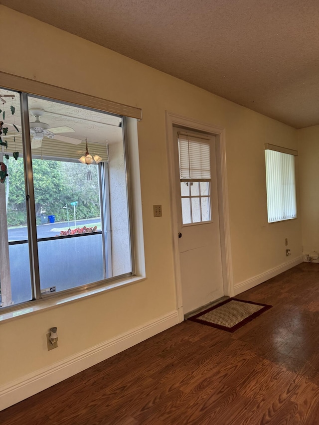 doorway with a textured ceiling, wood-type flooring, and ceiling fan