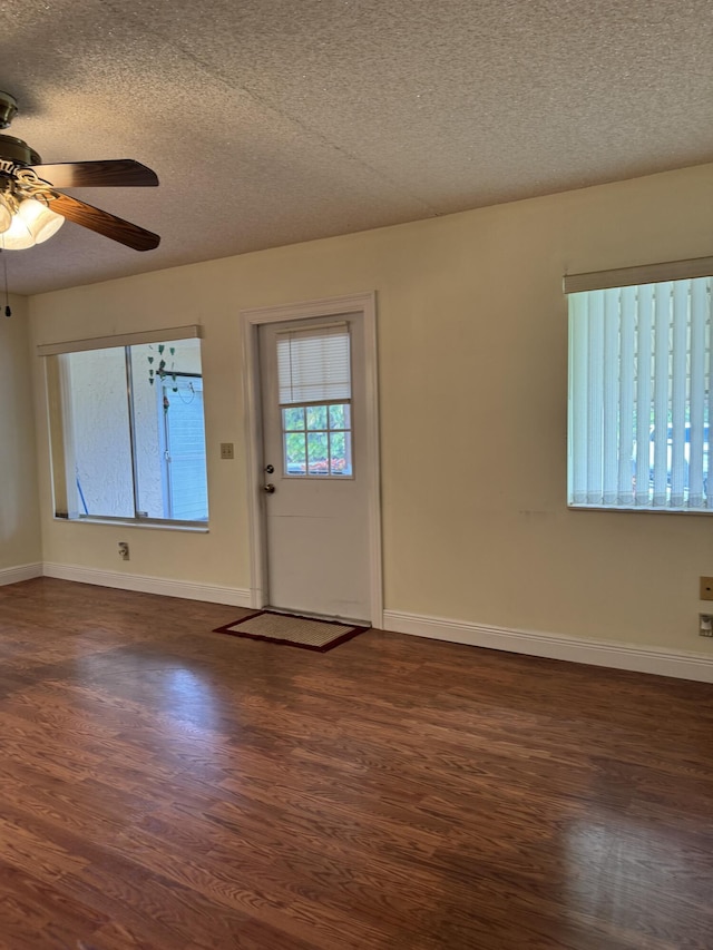 foyer with ceiling fan, a textured ceiling, and dark hardwood / wood-style flooring