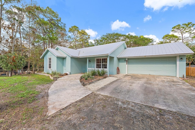 single story home with a garage, a front yard, and covered porch