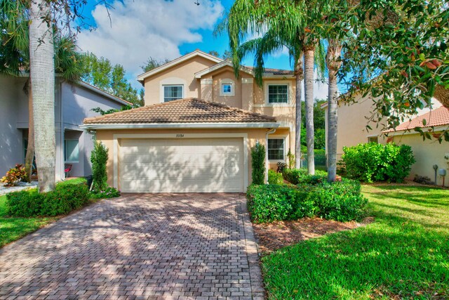 mediterranean / spanish home featuring a garage and a front yard