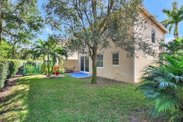 rear view of house with a lawn and a patio area