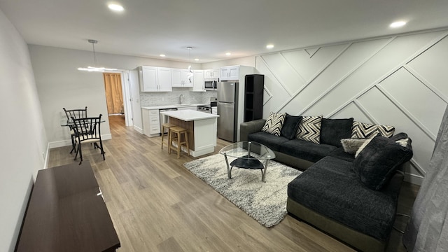 living room with sink and light hardwood / wood-style floors