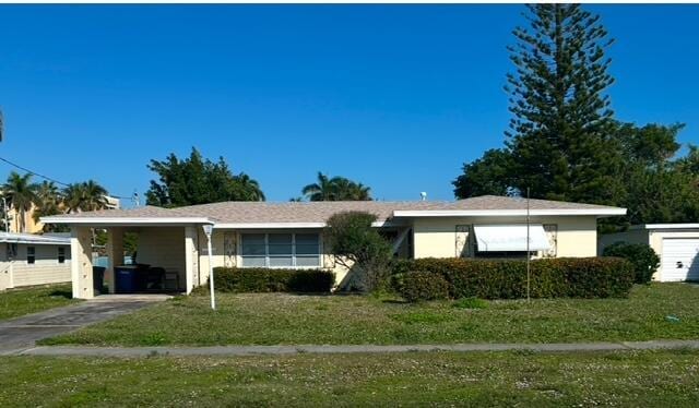 single story home featuring a carport and a front lawn