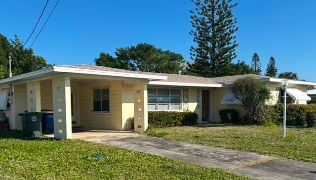 ranch-style house with a front lawn and a carport