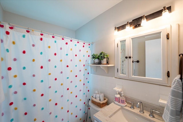 bathroom with walk in shower, vanity, and tile walls