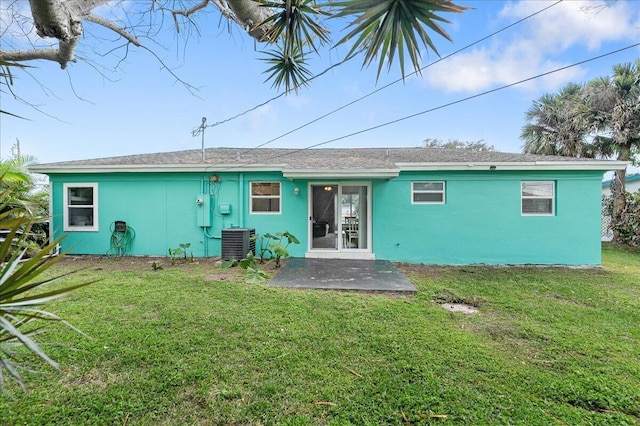 back of house with central AC and a yard