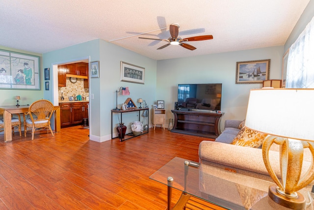 living room with wood-type flooring, a textured ceiling, and ceiling fan