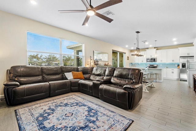 living room with ceiling fan and light hardwood / wood-style floors